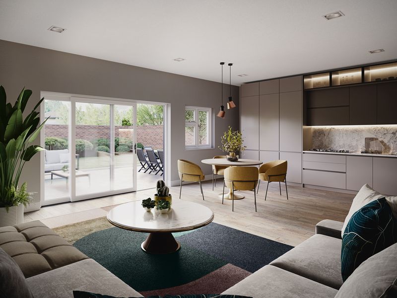 Modern open‑plan living and kitchen area with large sliding glass doors opening to a patio and garden