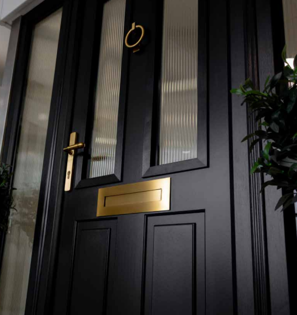 Black composite doors with gold brass door knocker and letterbox